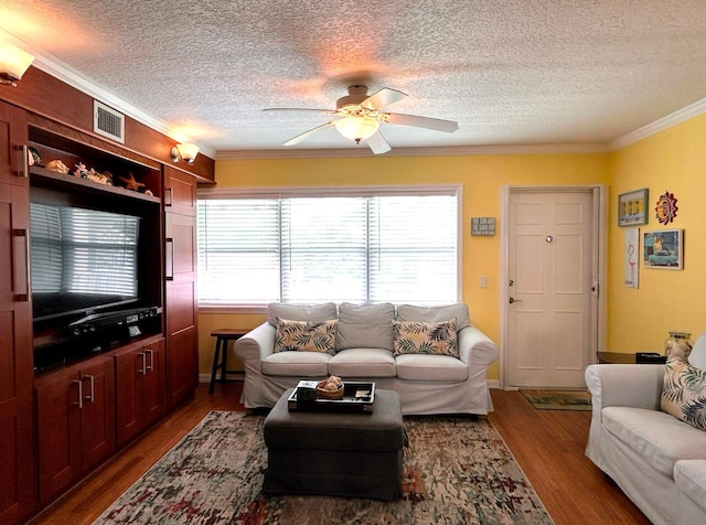 living room featuring ceiling fan, dark wood-type flooring, crown molding, and a textured ceiling