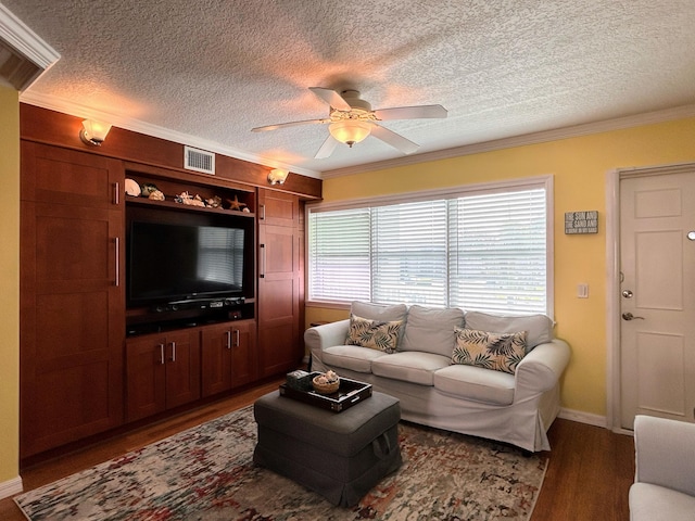 living room with ornamental molding, ceiling fan, a textured ceiling, and dark wood-type flooring