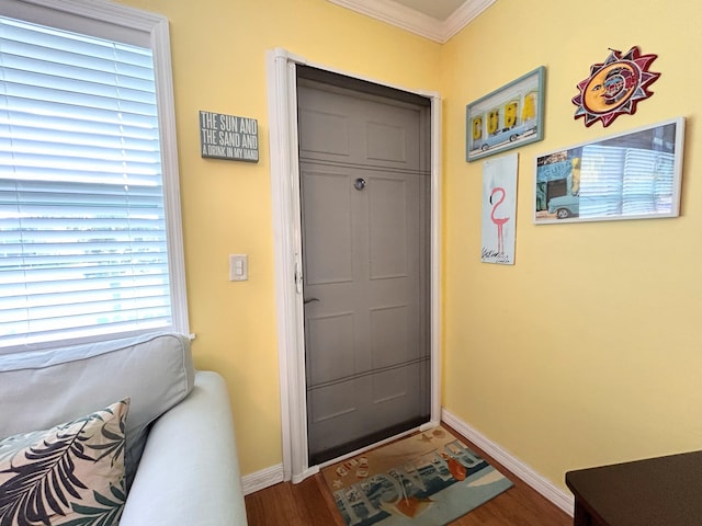 entryway with ornamental molding and hardwood / wood-style floors