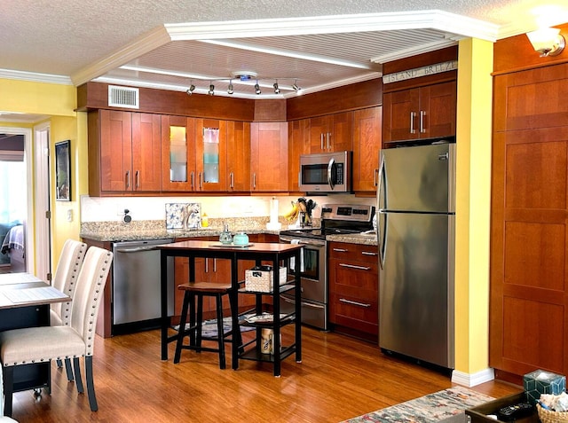 kitchen featuring appliances with stainless steel finishes, crown molding, and a textured ceiling