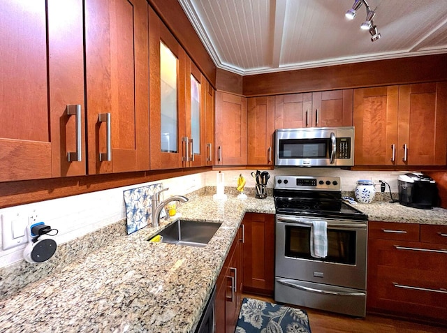 kitchen with light stone counters, hardwood / wood-style floors, crown molding, appliances with stainless steel finishes, and sink