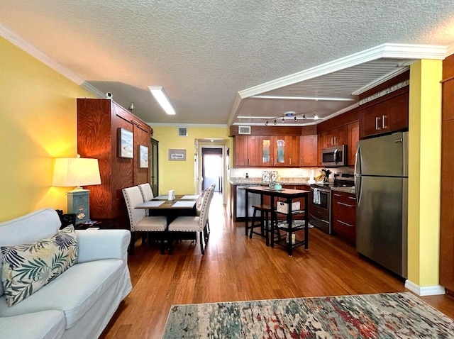 dining room featuring a textured ceiling, crown molding, and dark hardwood / wood-style flooring