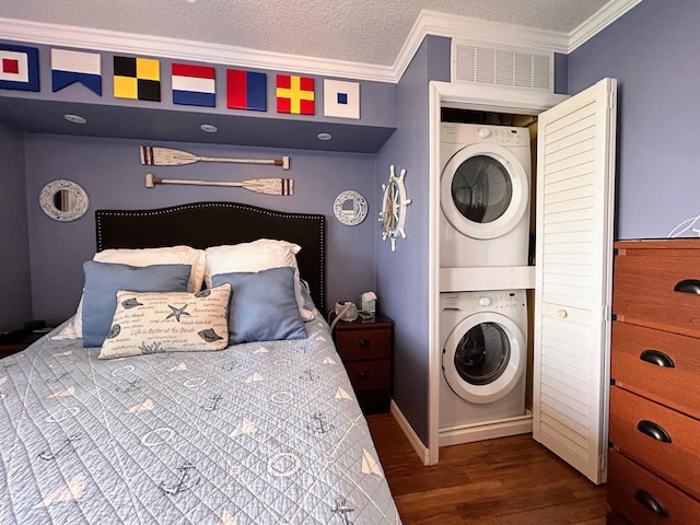 bedroom featuring stacked washer and clothes dryer, a textured ceiling, ornamental molding, and dark wood-type flooring