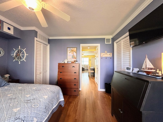 bedroom with a textured ceiling, ceiling fan, crown molding, and a closet