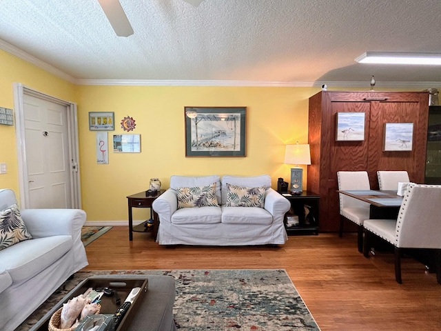 living room with a textured ceiling, ornamental molding, and hardwood / wood-style flooring