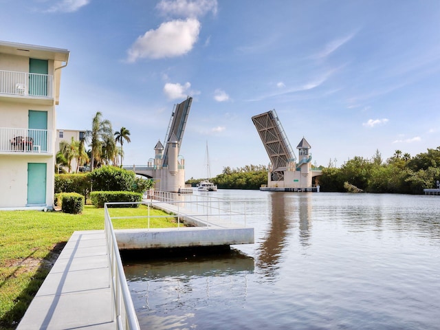 view of dock featuring a lawn and a water view