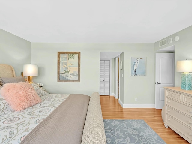 bedroom with light wood-type flooring and a closet