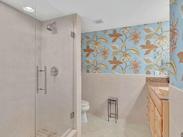 bathroom featuring walk in shower, vanity, tile walls, and toilet