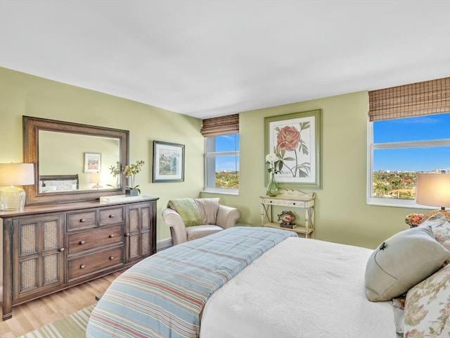 bedroom with light wood-type flooring and multiple windows