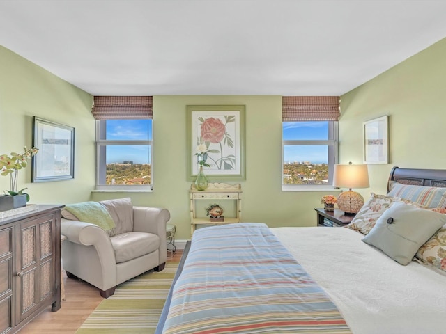 bedroom featuring multiple windows and light hardwood / wood-style flooring