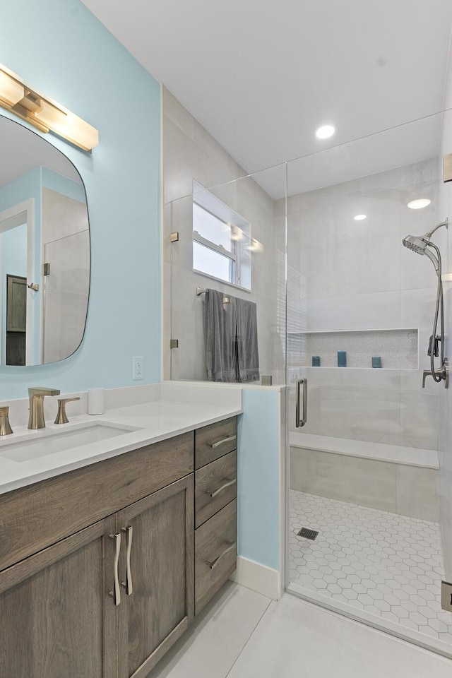 bathroom featuring tile patterned flooring, vanity, and walk in shower