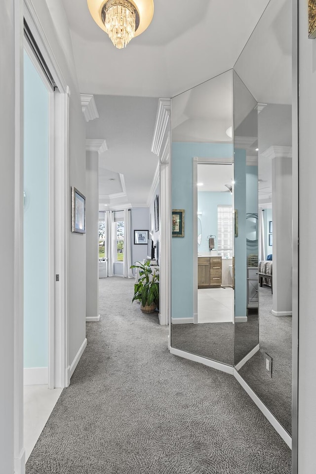 hallway with carpet flooring, a chandelier, and ornamental molding