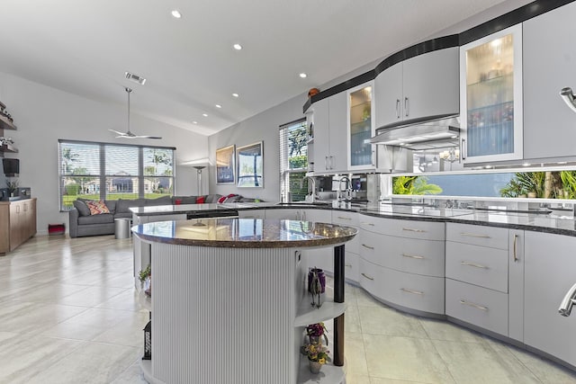 kitchen with black electric stovetop, vaulted ceiling, ceiling fan, sink, and a center island