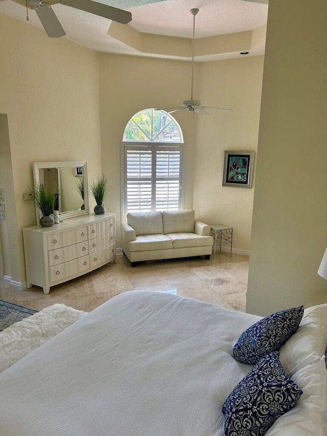 bedroom featuring ceiling fan, light tile patterned flooring, and a textured ceiling