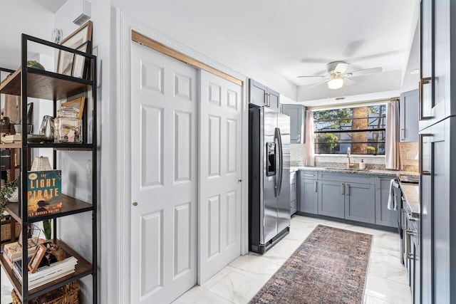 kitchen featuring light stone counters, range, ceiling fan, sink, and stainless steel fridge with ice dispenser