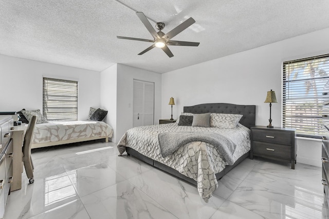 bedroom with ceiling fan, a textured ceiling, and a closet