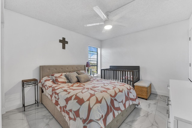 bedroom featuring ceiling fan and a textured ceiling