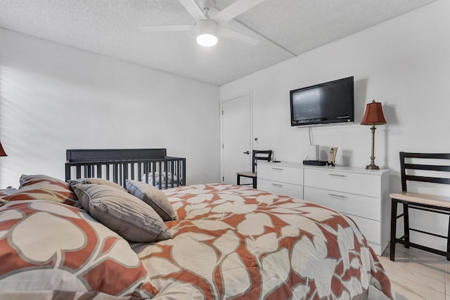 bedroom with ceiling fan and a textured ceiling