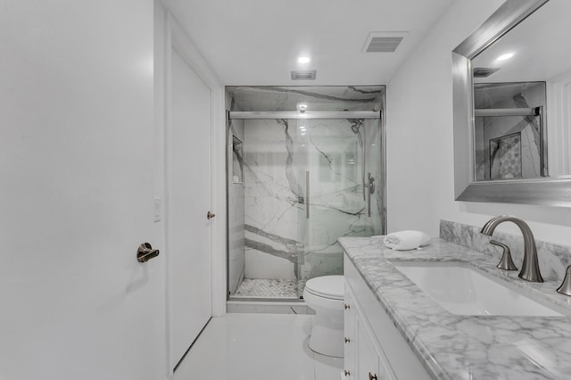 bathroom with vanity, a shower with door, and toilet