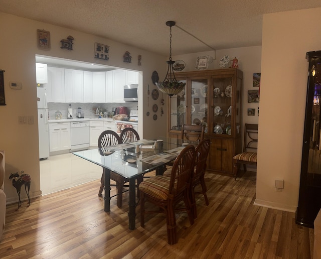 dining area with a textured ceiling and hardwood / wood-style flooring