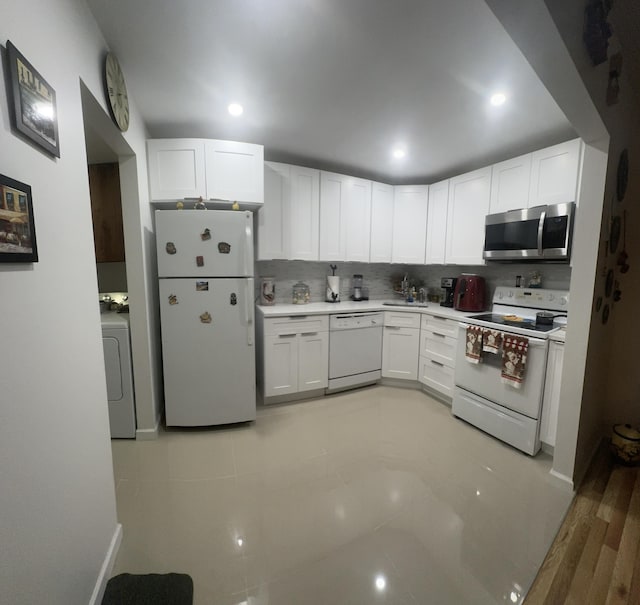 kitchen featuring decorative backsplash, white cabinetry, washer / dryer, and white appliances