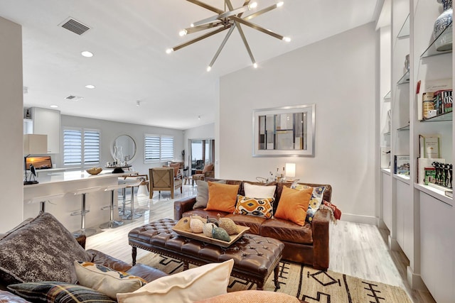 living room featuring an inviting chandelier and light hardwood / wood-style floors