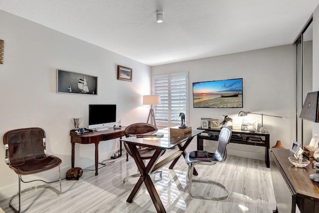 home office with light hardwood / wood-style flooring