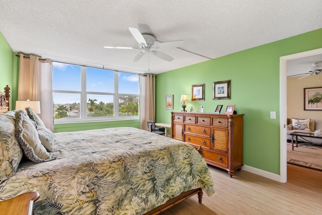 bedroom featuring ceiling fan, a textured ceiling, and light hardwood / wood-style flooring