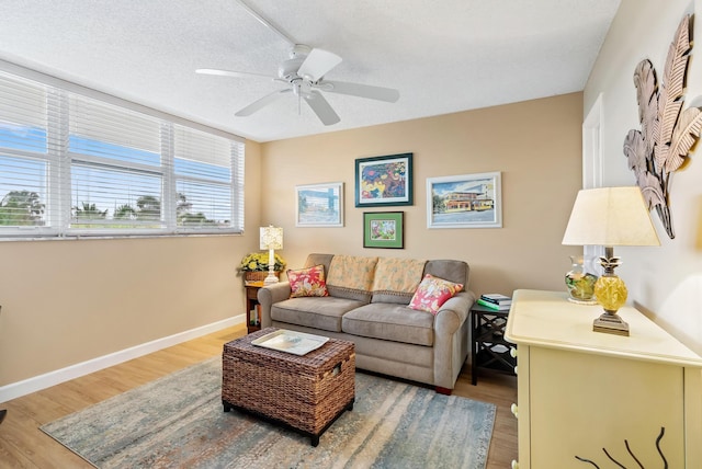 living room featuring ceiling fan, a textured ceiling, and hardwood / wood-style floors