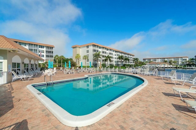 view of pool with a water view and a patio