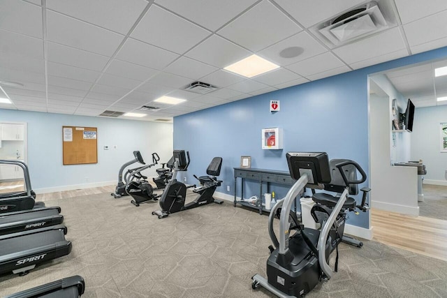 gym with light colored carpet and a paneled ceiling