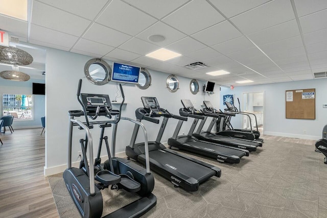 gym with a paneled ceiling and hardwood / wood-style flooring