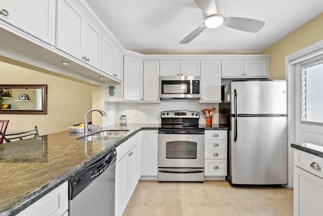 kitchen featuring white cabinets, appliances with stainless steel finishes, and dark stone countertops