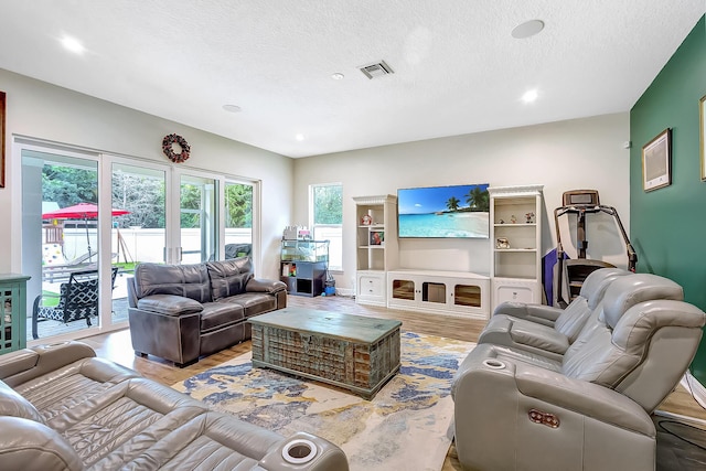 living room featuring a textured ceiling and light wood-type flooring