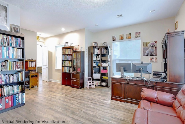 home office featuring light hardwood / wood-style floors and a textured ceiling