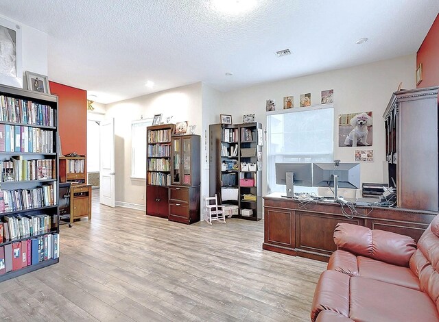 office space featuring light hardwood / wood-style flooring and a textured ceiling