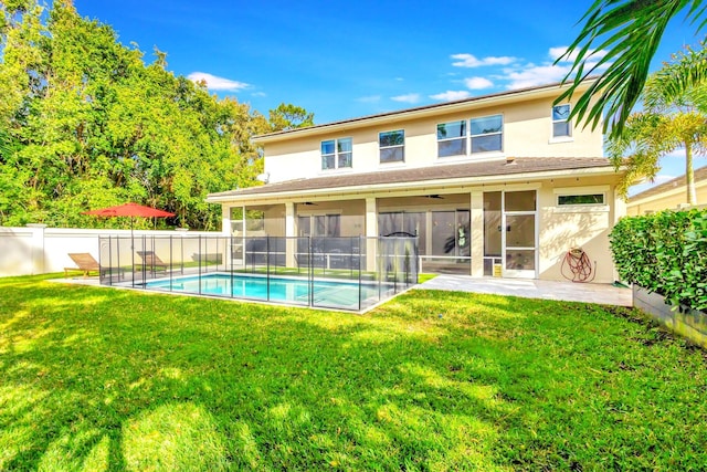 back of house featuring a fenced in pool, a lawn, ceiling fan, a patio area, and a sunroom