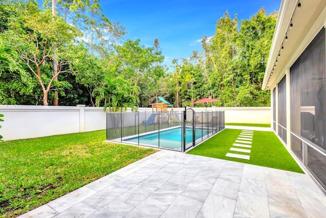 view of pool with a lawn, a patio, and a playground