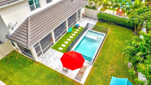 view of swimming pool featuring a yard and a sunroom