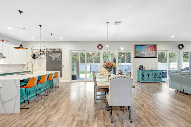 dining space featuring sink and light wood-type flooring