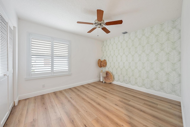 empty room with light hardwood / wood-style flooring and ceiling fan