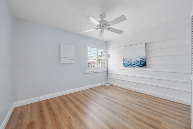 spare room with light hardwood / wood-style floors, a textured ceiling, and ceiling fan