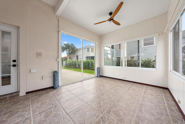 unfurnished sunroom with ceiling fan