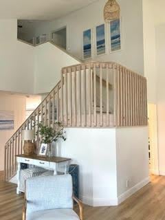 stairs featuring hardwood / wood-style flooring and a towering ceiling