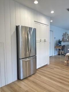 kitchen featuring light hardwood / wood-style floors, white cabinets, and stainless steel refrigerator