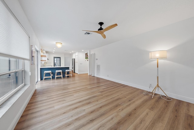 unfurnished living room with ceiling fan and light wood-type flooring