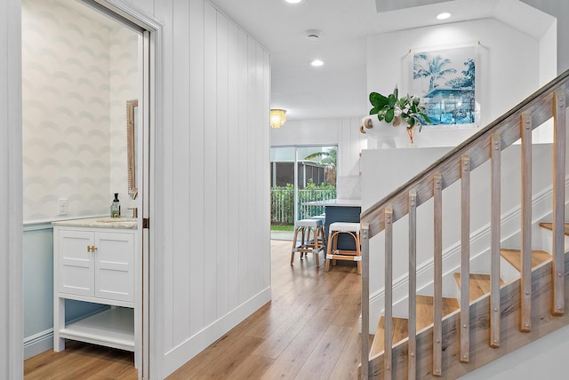 stairs featuring sink and hardwood / wood-style floors