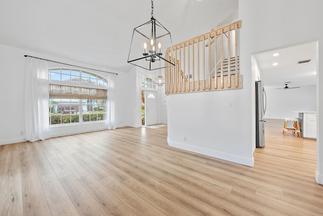 unfurnished dining area featuring light wood-type flooring and an inviting chandelier