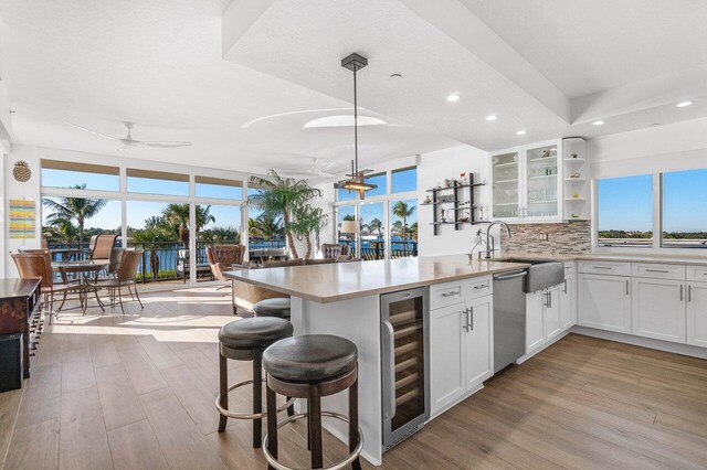 sunroom with ceiling fan and a water view