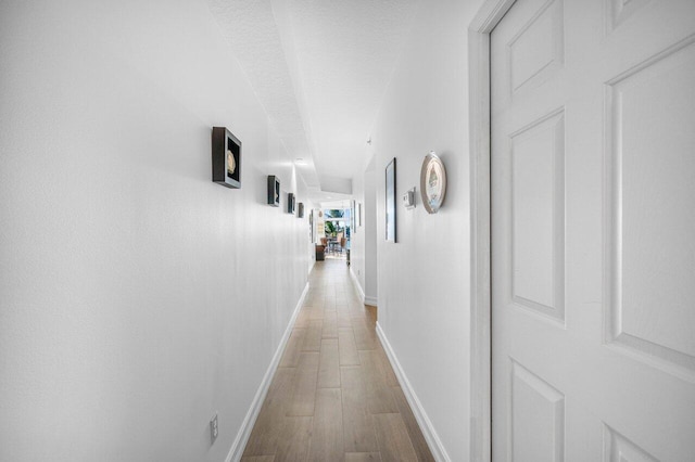 hallway with hardwood / wood-style flooring